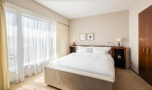 a bedroom with a large bed and a large window at Grand Hyatt Berlin in Berlin