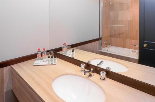 a bathroom with two sinks and a large mirror at Southern Sun Cape Sun in Cape Town