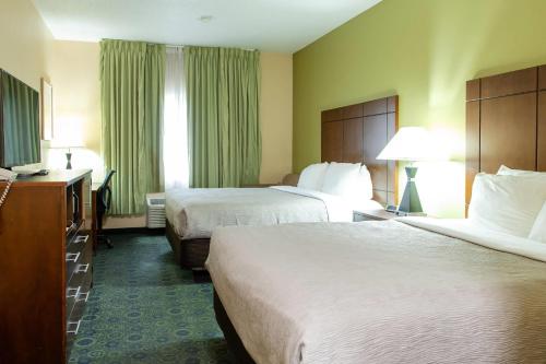 a hotel room with two beds and a desk at Quality Inn & Suites Bloomington I-55 and I-74 in Bloomington