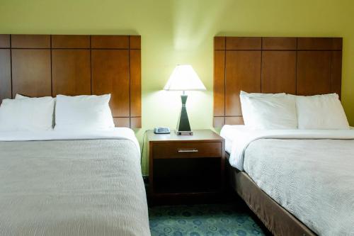 a hotel room with two beds and a lamp on a table at Quality Inn & Suites Bloomington I-55 and I-74 in Bloomington