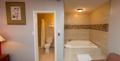 a bathroom with a bath tub and a toilet at Scottish Inn and Suites - Bensalem-Philadelphia in Bensalem