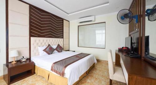 a bedroom with a bed and a desk and a television at Thai An Hotel in Cửa Lò