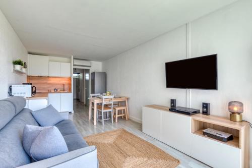 un salon avec un canapé bleu et une télévision à écran plat dans l'établissement Appartement à 70m de la plage, à La Grande Motte