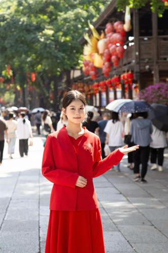a woman in a red dress standing on a street at Kempinski Hotel Fuzhou in Fuzhou