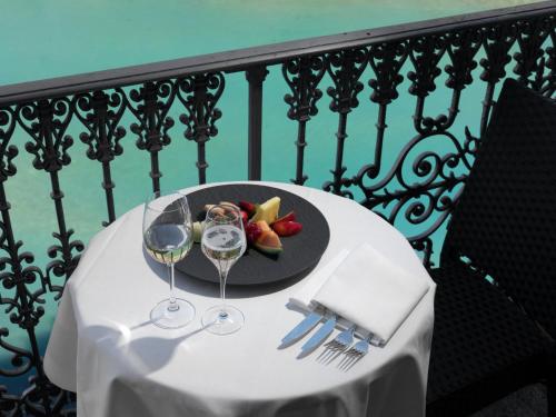 a table with a plate of food and wine glasses at Grand Hotel Beau Rivage Interlaken in Interlaken