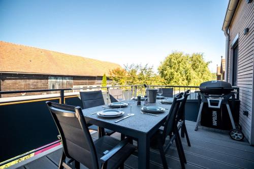 a table and chairs on a balcony with a grill at Ferienwohnung ScheunenBlick in Göhren-Lebbin