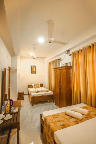 a hotel room with two beds and a table at Hotel Silver Horse Dambulla in Dambulla