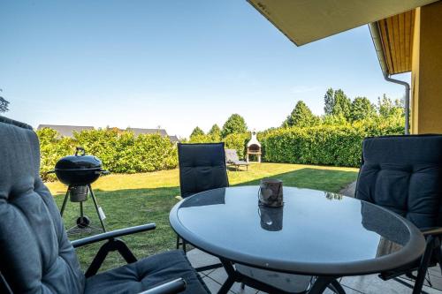 a patio with a table and chairs and a grill at One Putt Erdgeschoss in Göhren-Lebbin