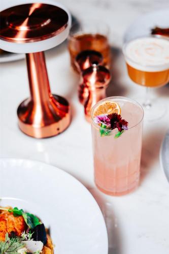 a table topped with plates of food and a drink at Conrad Nashville in Nashville