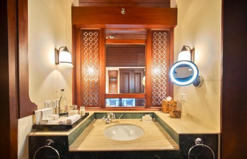 a bathroom with a sink and a mirror at The Leela Kovalam, A Raviz Hotel in Kovalam