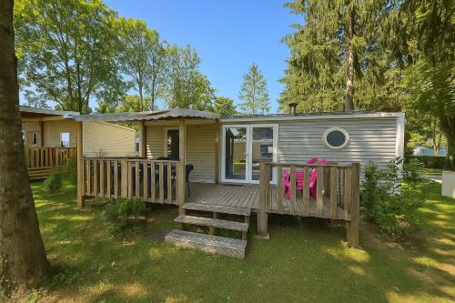 a tiny house with a porch and a deck at Luxus Mobile Home beim Europa-Park, voll klimatisiert mit Wi-Fi! in Boofzheim