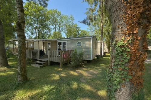 a mobile home in a yard with trees at Luxus Mobile Home beim Europa-Park, voll klimatisiert mit Wi-Fi! in Boofzheim