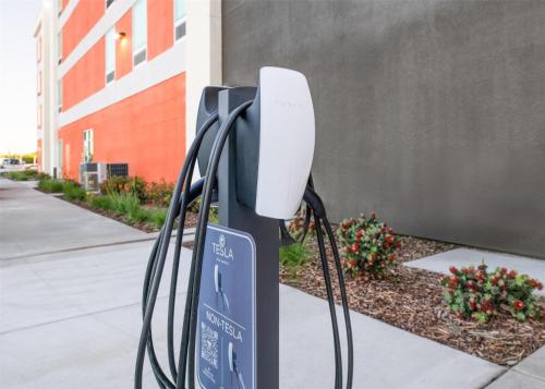 a computer monitor is attached to a pole on a sidewalk at Home2 Suites By Hilton Woodland Sacramento in Woodland