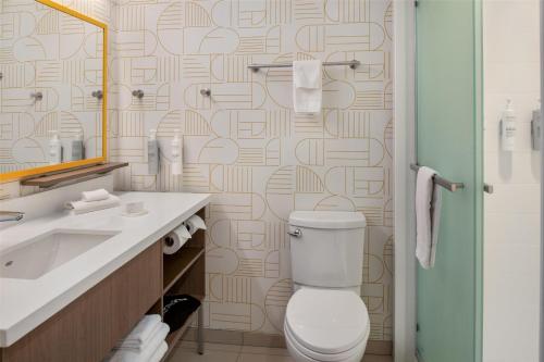 a bathroom with a toilet and a sink and a mirror at Home2 Suites By Hilton Woodland Sacramento in Woodland