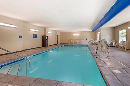 a large swimming pool with blue water in a building at Comfort Inn & Suites Morgan - South Ogden in Morgan