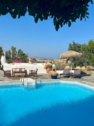 a large swimming pool with chairs and a table at Casa Paros in Parikia
