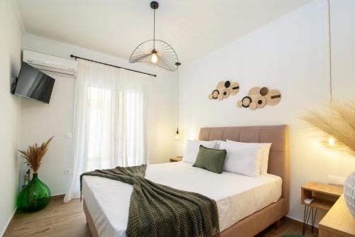 a bedroom with a large bed with white sheets at Venetis Family House in Gouvia