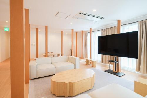a living room with a white couch and a flat screen tv at Starry Stay Villa NISHIATAMI in Atami