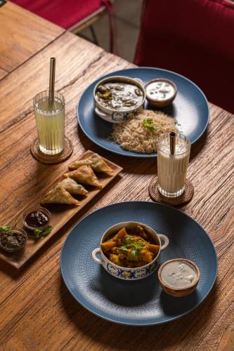 Una mesa de madera con platos de comida encima. en Flow - Temple of Health - Ayurvedic Cafe, Steam Room & Ice Plunge Gili Air, en Gili Air