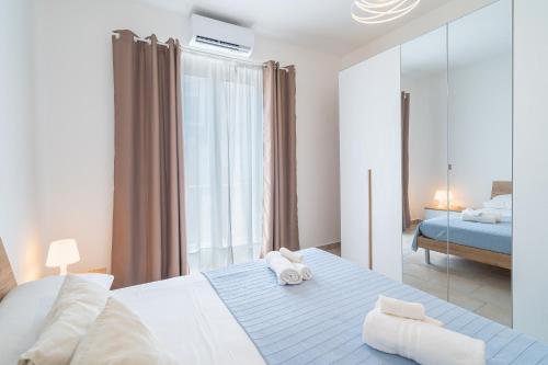 a bedroom with a large bed and a mirror at Casa Alejandra a Pachino centro in Pachino
