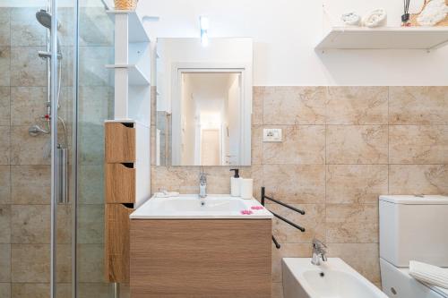 a bathroom with a sink and a mirror and a toilet at Casa Alejandra a Pachino centro in Pachino