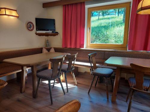 a restaurant with tables and chairs and a window at Farmhouse in Ramsau near Ski Slopes in Ramsau im Zillertal