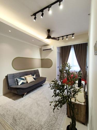 a living room with a couch and a vase of flowers at Tranquil Transit Horizon Suites in Kampong Melot