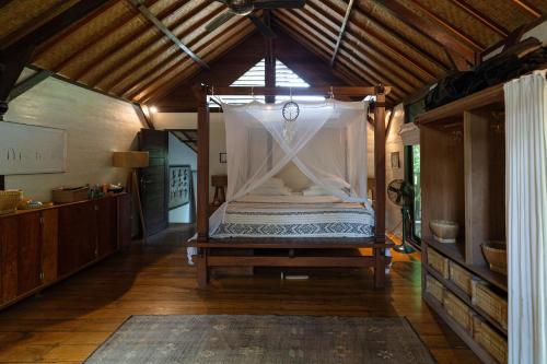 a bedroom with a canopy bed in a room at Flow Gili Air in Gili Islands
