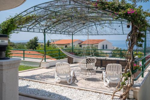 a group of chairs sitting under a gazebo at Villa Božica - sea view stone villa with free parking in Makarska