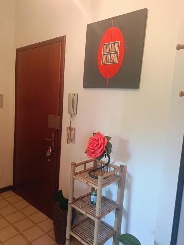 a rose in a vase on a shelf next to a door at Grazioso bilocale in Giusvalla