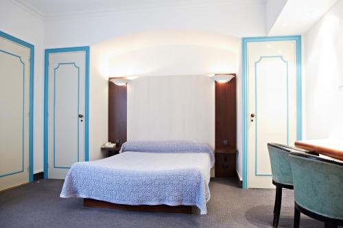 A bed or beds in a room at Hôtel Mets et Plaisirs