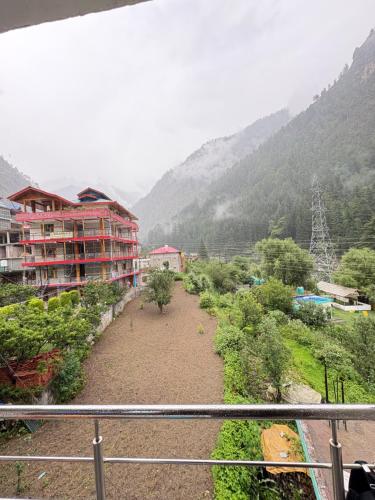 a view from a balcony of a city with mountains at Happy Heaven Guesthouse, Chojh in Kasol