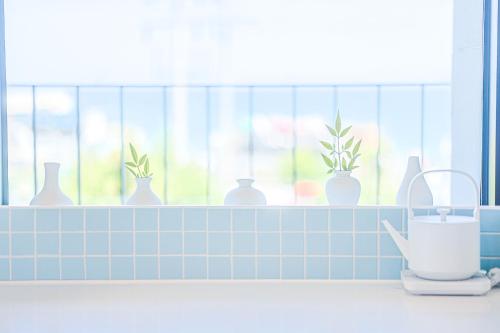 a kitchen counter with vases on a window ledge at Paul Mare Pool Villa in Busan