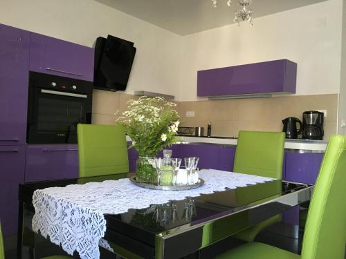 a kitchen with a table with green chairs and purple cabinets at Casa di Lavanda in Hvar