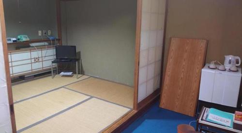 a room with a reflection of a room with a mirror at AKISAWA HOTEL in Shimanto