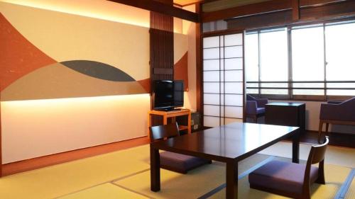 a living room with a table and a television at Ikadasou Sanjou in Shima