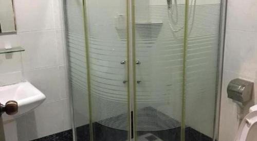 a glass shower in a bathroom with a sink at Happy Village Kundasang in Ranau