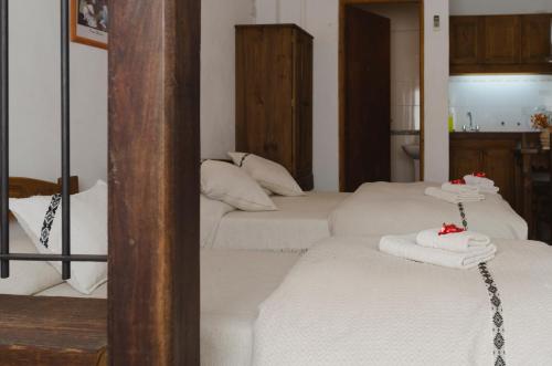 ein Zimmer mit 3 Betten und weißen Handtüchern darauf in der Unterkunft La Posta Tigre in Tigre