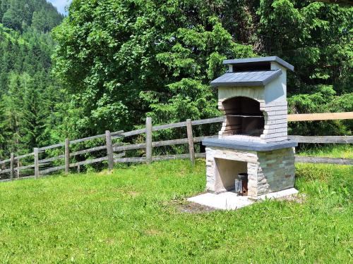 a brick oven in a field next to a fence at Ferienhaus Hinterhabneralm in Petersberg