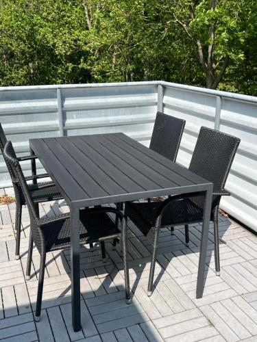 a black table and chairs on a patio at Pilegården Ferieboliger in Læsø