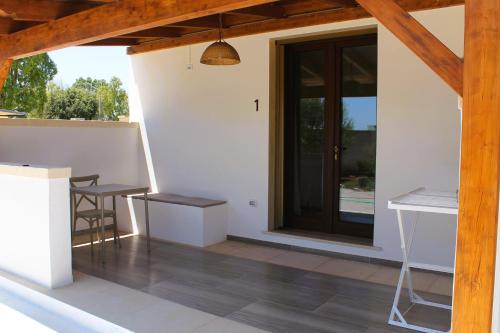 a patio with a table and chairs and a door at Tenuta Petra Chiara in Torre Lapillo