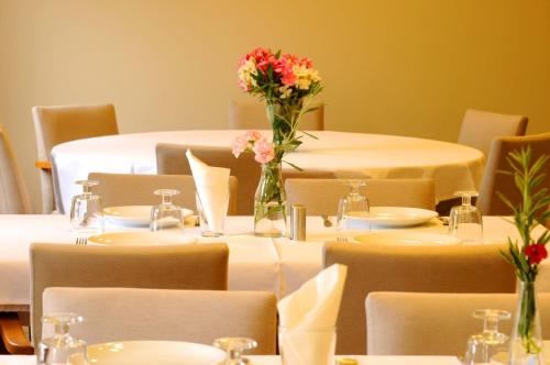 a group of tables with flowers in a room at Teos Lodge Pansiyon in Siğacık