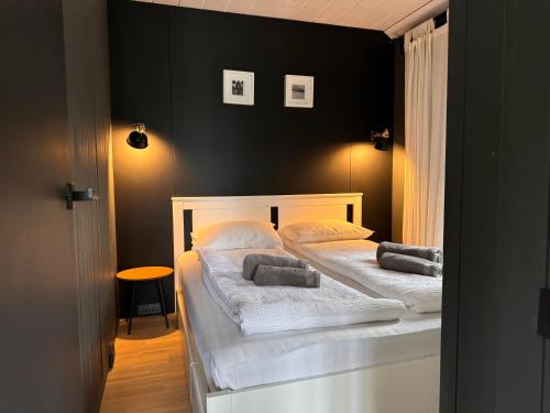 two beds in a bedroom with black walls at HARMONY Slow Living Stay in Bigauņciems