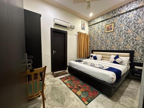 a bedroom with a bed and a door with a wall at Hotel Aaradhya Residency in Agra