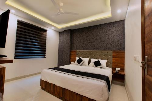 a bedroom with a large bed and a window at VERTTU Horizon Delhi Airport Free Airport Pick Up in New Delhi