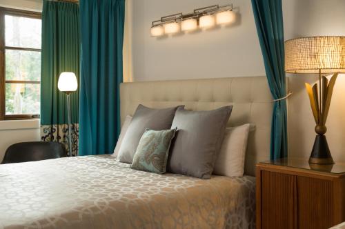 a bedroom with a bed with blue curtains and a lamp at Black Dolphin Inn in New Smyrna Beach