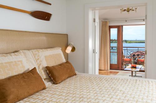 a bedroom with a bed with a view of a balcony at Black Dolphin Inn in New Smyrna Beach