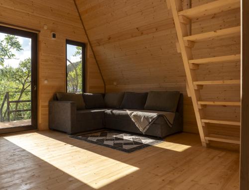 a living room with a couch in a wooden cabin at Pinehouse Urtkhva in Surami 