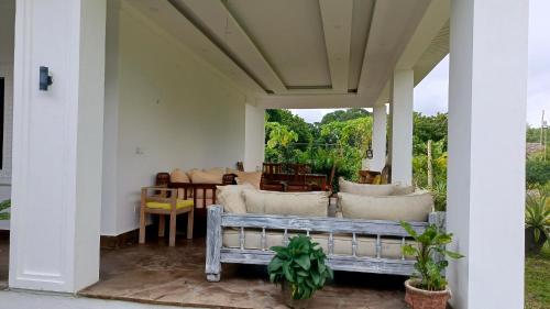 a porch with a bench and a table at Shalom Wellspring Homestay in Malindi