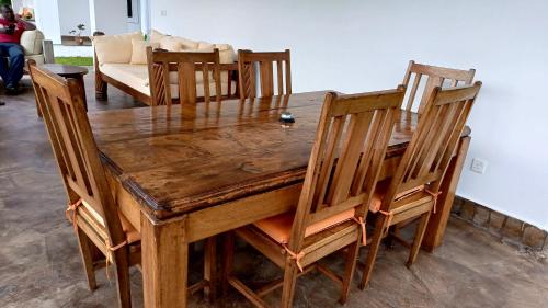 a wooden dining room table with wooden chairs at Shalom Wellspring Homestay in Malindi